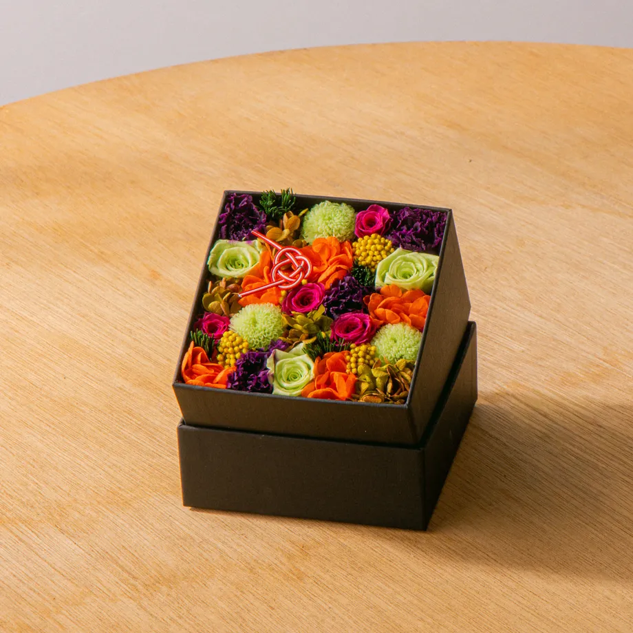 黒いボックスに敷き詰めたピンクとグリーンの花