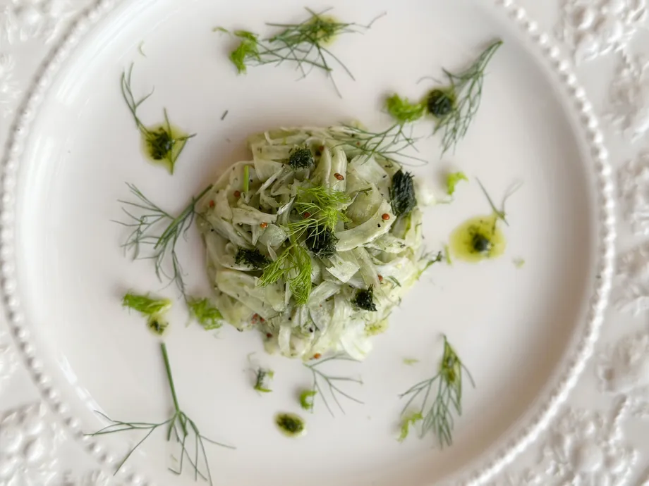 白い皿に盛られた野菜のサラダとハーブ