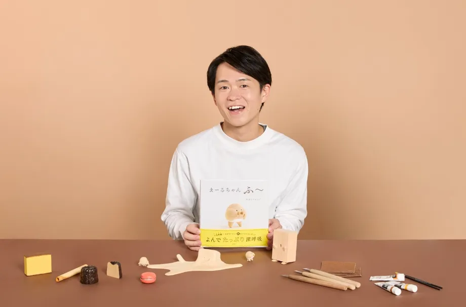 絵本と作品を手にするキボリノコンノさん