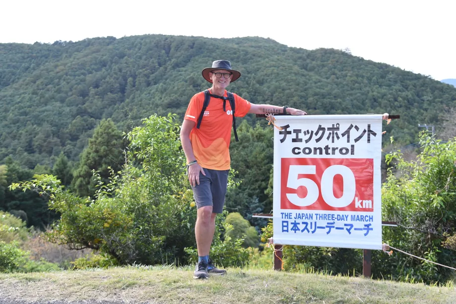 50kmの表示のそばに立つ参加者