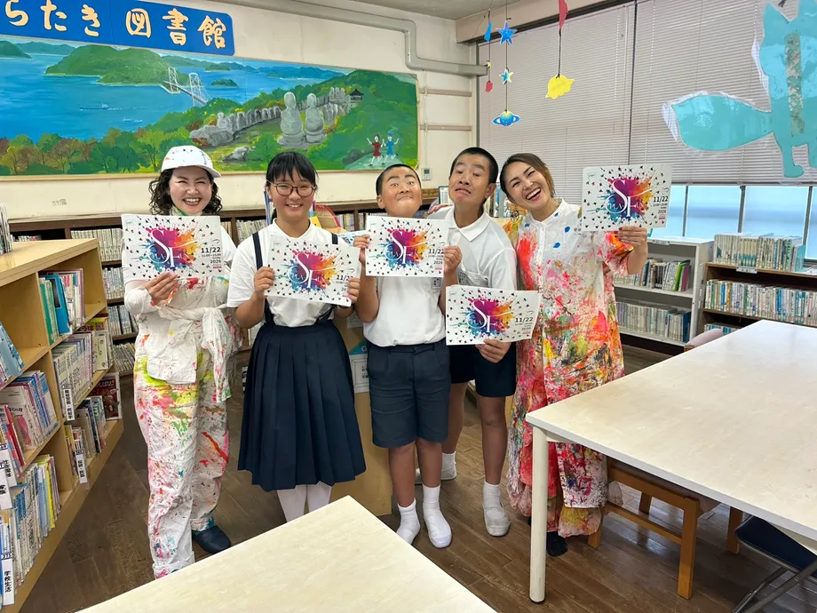 学校で児童と主催者がチラシを持つ様子