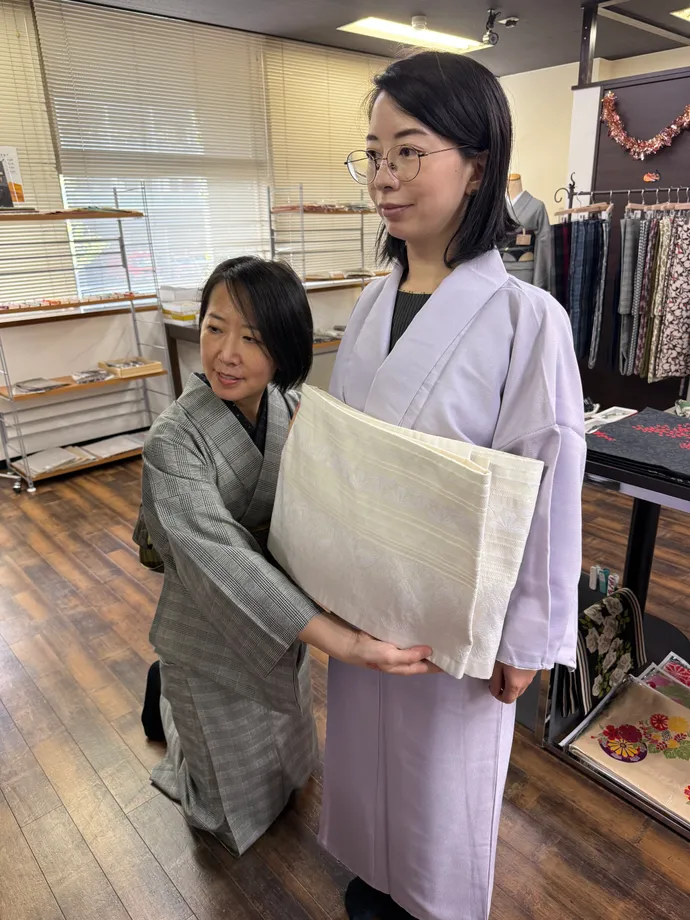 スタッフが着物の着用を手伝う様子