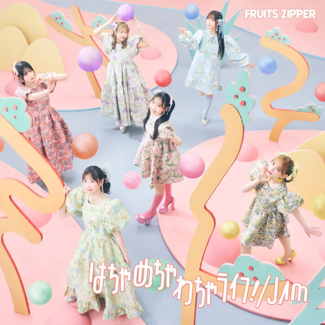 FRUITS ZIPPERのメンバーがカラフルな衣装を着て、ポップな背景でポーズをとっている画像です。