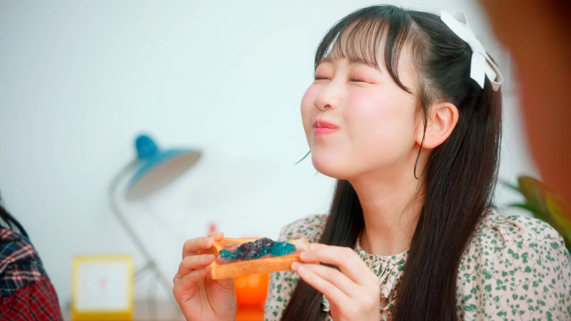 トーストを食べる女性のクローズアップ。彼女は満足そうな表情で目を閉じている。