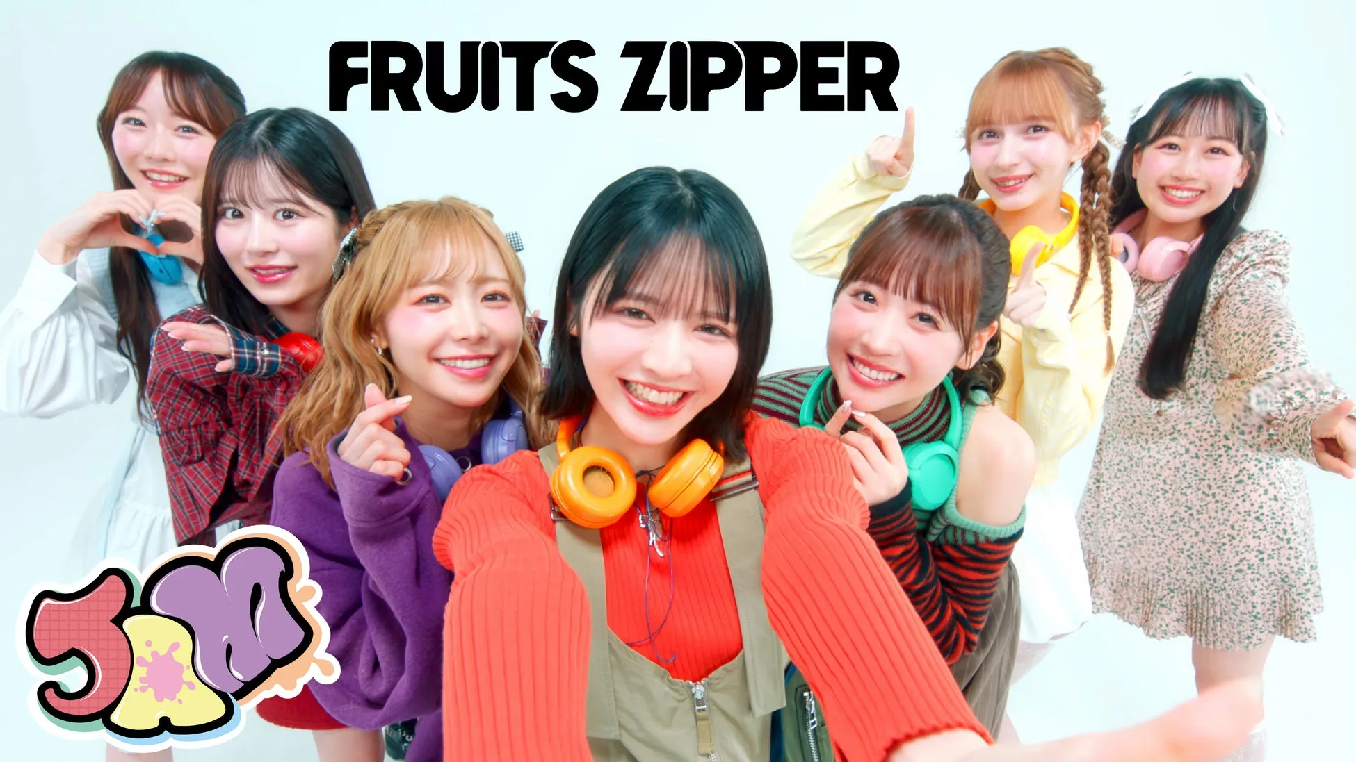 FRUITS ZIPPERのメンバー7人が笑顔で写っている写真です。全員がカメラ目線で、ポーズをとっています。