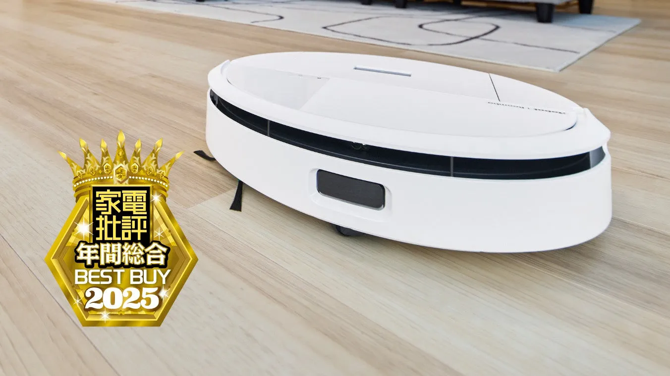 フローリングの上を走る白いロボット掃除機。金色の王冠と六角形のバッジが添えられており、「家電批評 年間総合 BEST BUY 2025」と書かれている。