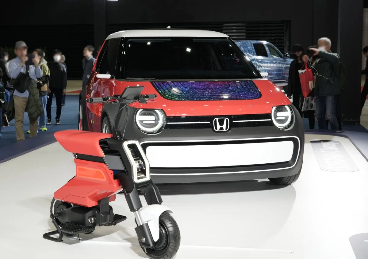 赤と黒のホンダのコンセプトカーと電動バイクが展示されている写真です。