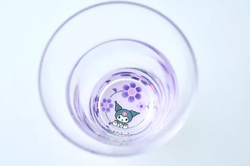 グラスの内側から見た、紫色の花とキャラクターが描かれたデザイン。