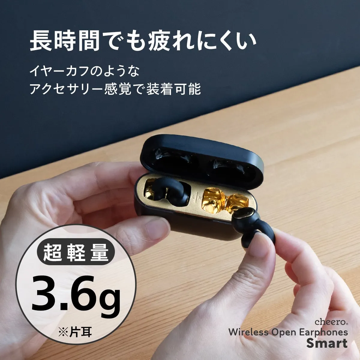 黒と金のイヤホンケースとイヤホンを持つ手の写真。イヤホンは片耳3.6gの超軽量で、長時間装着しても疲れにくいとのこと。