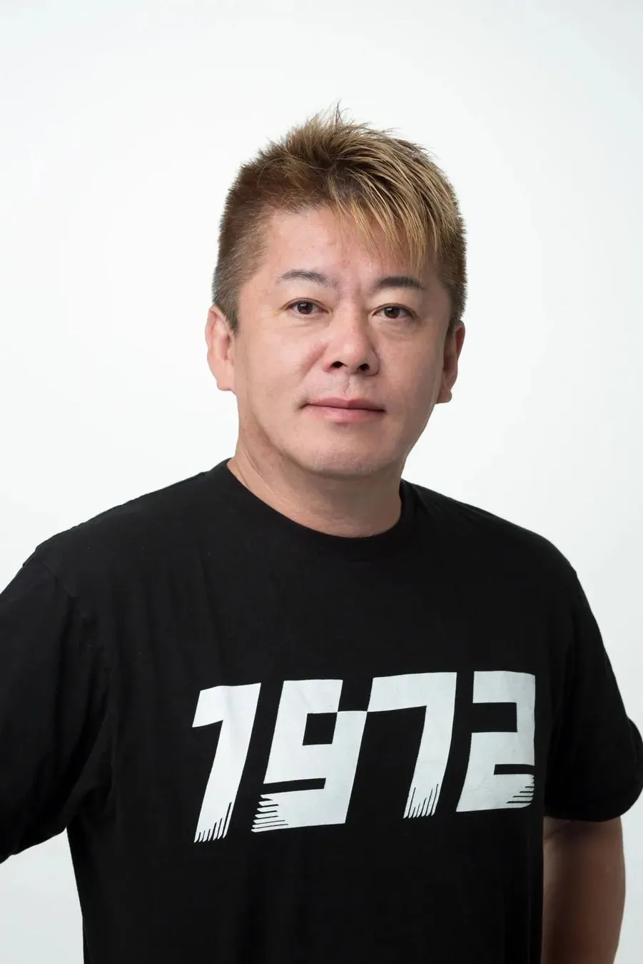 黒いTシャツを着た男性のポートレート。Tシャツには「1972」の文字が白抜きでプリントされている。