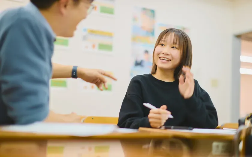 教室で話す若い女性と男性の様子。
