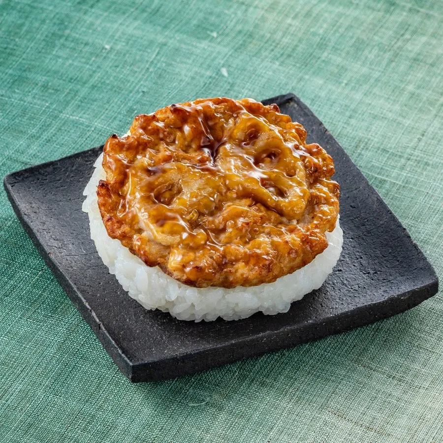 ご飯の上に照り焼きのようなものが乗った料理の写真です。黒いお皿に盛り付けられています。