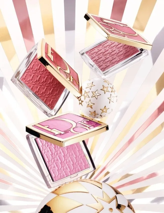 Diorのチークが複数写った写真。チークはピンクや赤色で、星の模様が入った容器に入っている。背景は金と白のストライプ模様。