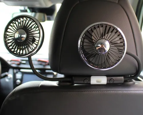 車のヘッドレストに取り付けられた2つの黒いファンのクローズアップ写真です。ファンは丸く、金属製の縁があり、黒い羽根があります。ファンは黒いアームでヘッドレストに接続されています。