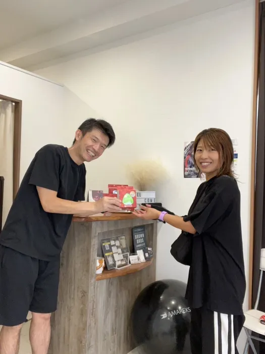 男性が女性に商品を手渡している様子を捉えた写真