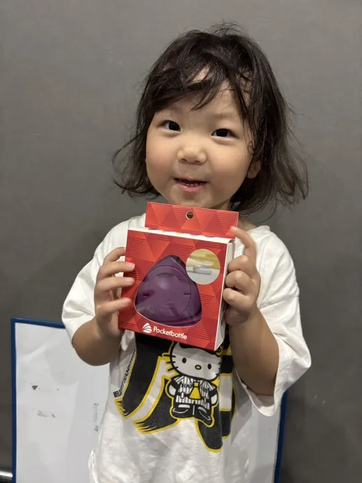 女の子がPocketbottleの箱を持って微笑んでいる写真