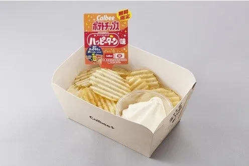 カルビーのポテトチップス、ハッピーターン味のパッケージ。ポテトチップス、ディップソース、紙製の容器が含まれています。