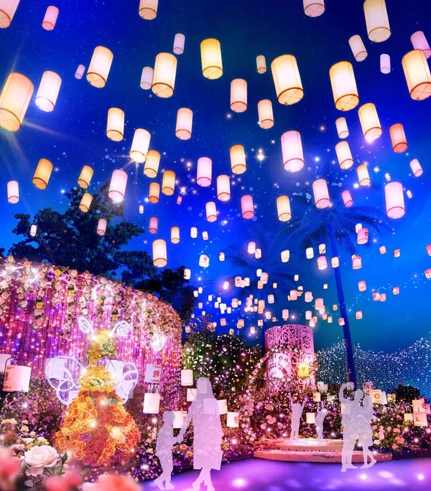 夜空に浮かぶランタンと花々が美しい幻想的な風景。人々がランタンを見上げ、光に包まれた空間を作り出している。