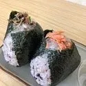 おにぎりが2つ並んだ写真。海苔で巻かれ、具材がトッピングされている。