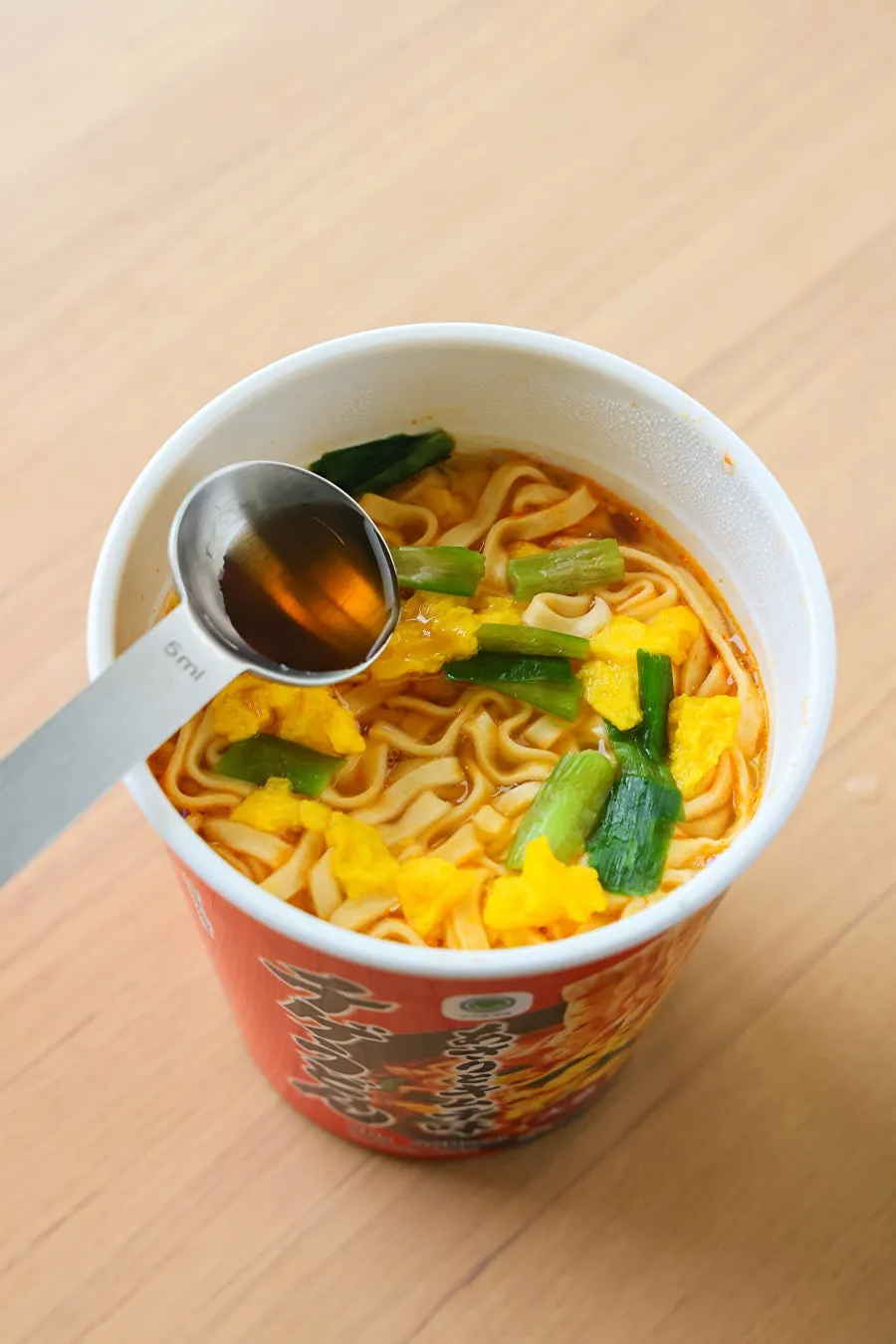 カップ麺に調味料を投入している様子