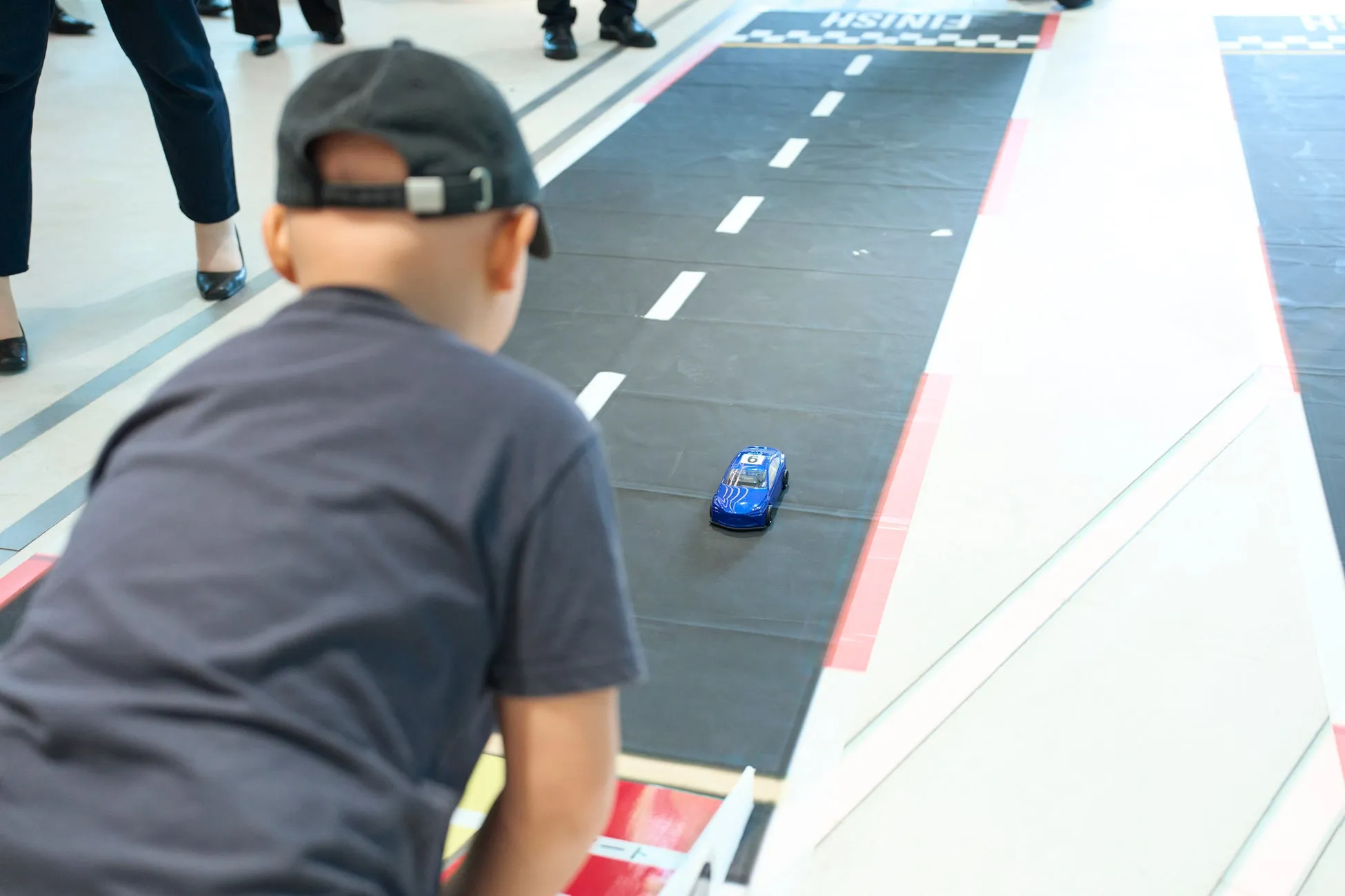 子供がミニカーのレースを見ている様子