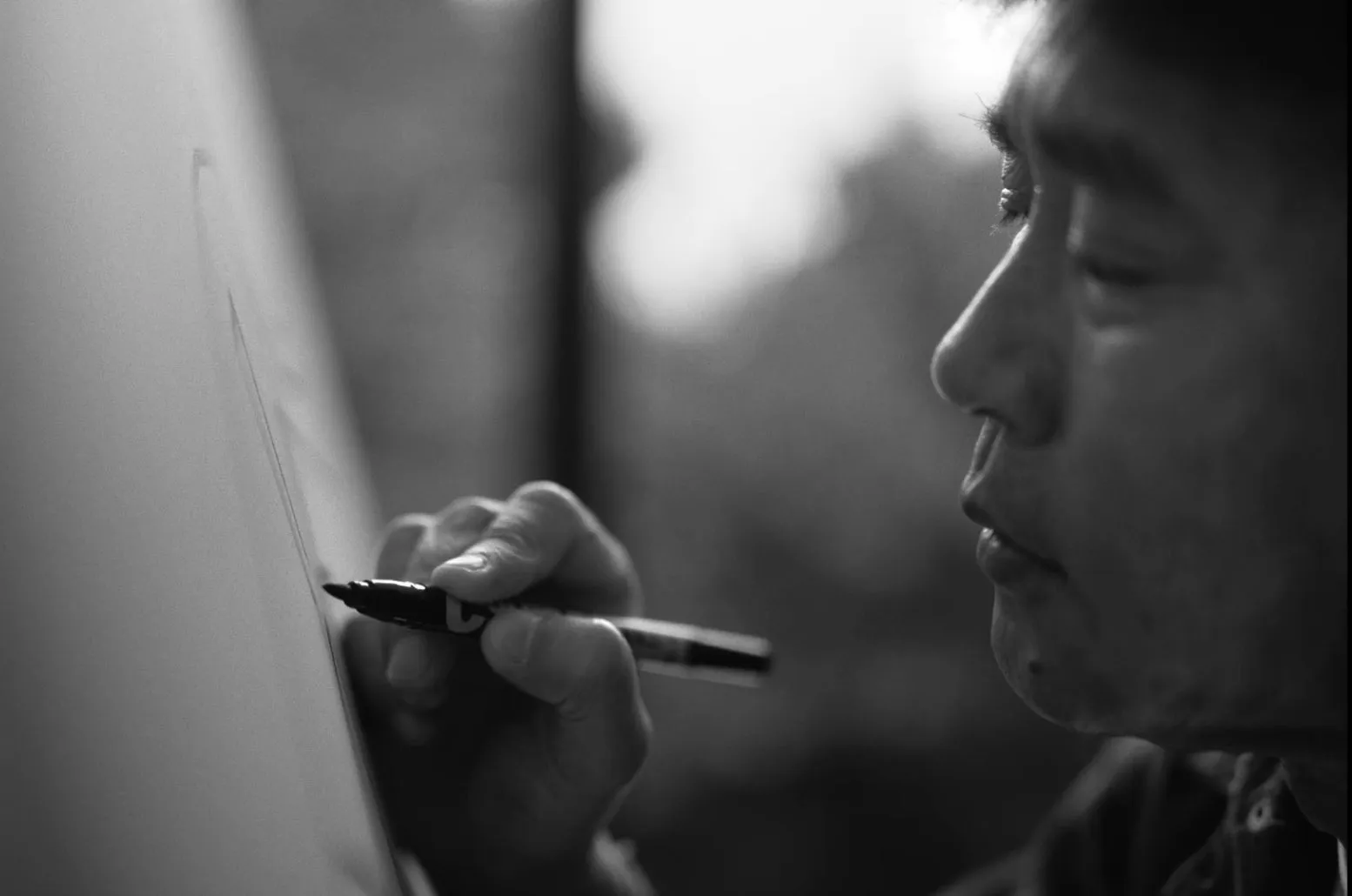 ペンで描く人物のモノクロ写真