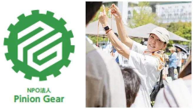 イベントで紐を扱う女性。笑顔でカメラを見ている。
