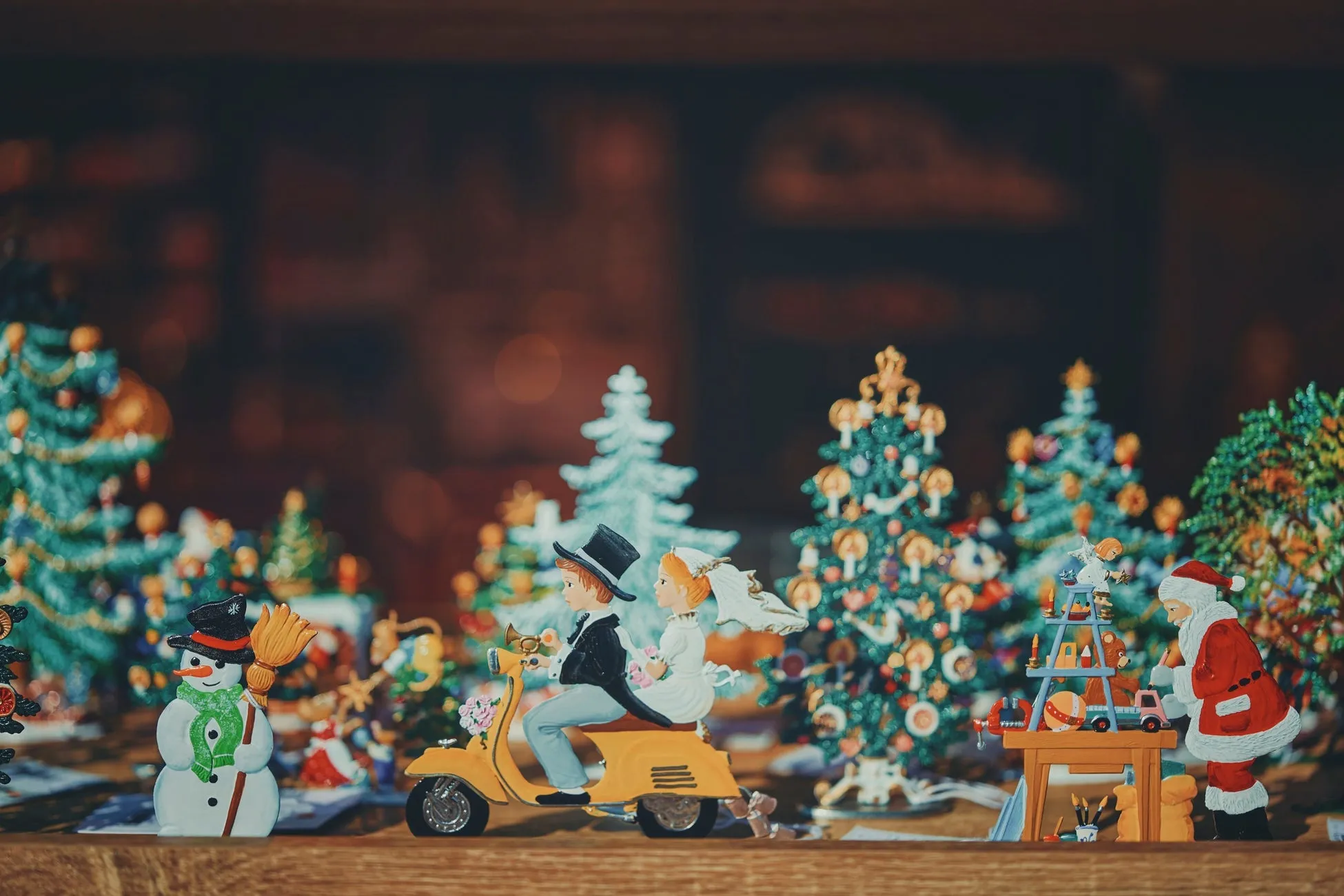 クリスマスの装飾が施されたシーン。中央にはバイクに乗った新郎新婦のフィギュアがあり、その周りには雪だるま、クリスマスツリー、サンタクロースのフィギュアが配置されています。