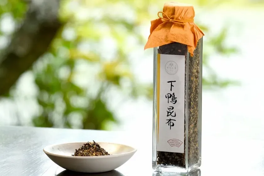 ガラス瓶に入った昆布と、小皿に盛られた昆布の画像。背景には緑のぼかしが見える。