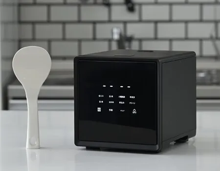白いしゃもじと黒い炊飯器が並んでいます。炊飯器にはメニューが表示されています。