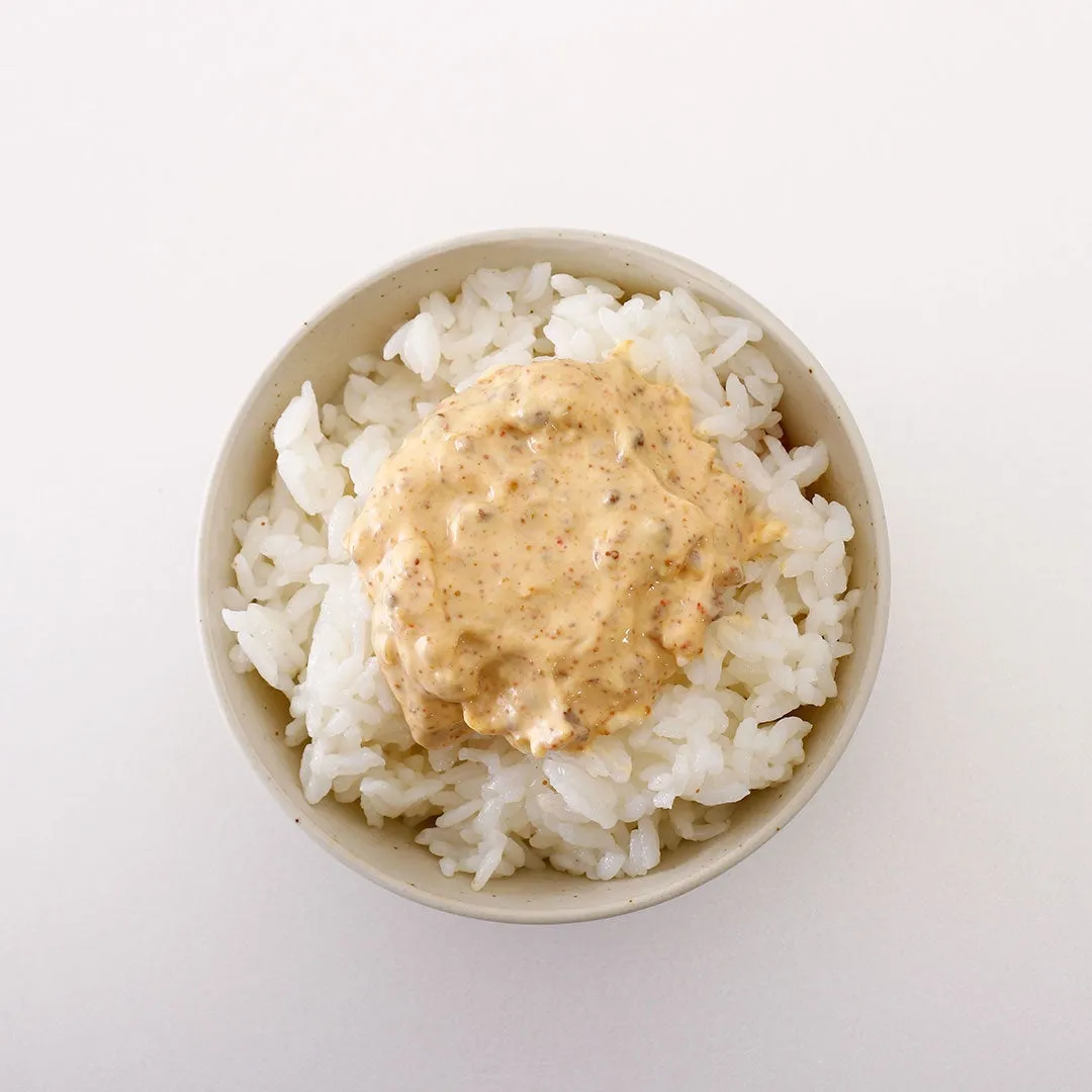 ご飯の上にソースがかけられた料理の写真です。白いご飯の上に、茶色いソースがたっぷりとかけられています。器はシンプルで、背景は白です。