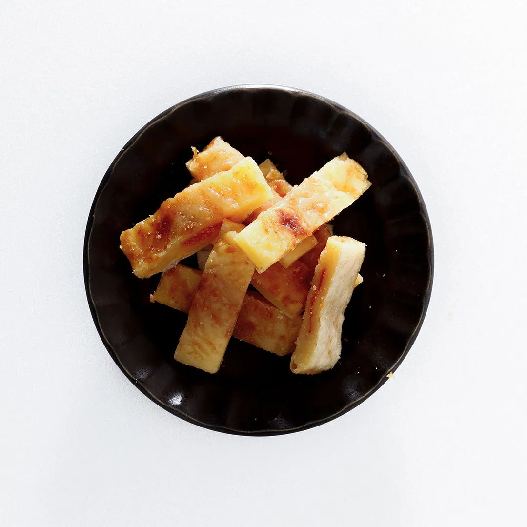 黒いお皿に盛り付けられた、焼き色がついた長方形の食べ物のクローズアップ写真。