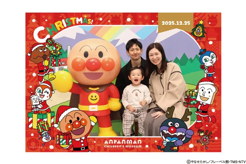 アンパンマンと家族がクリスマスの記念写真を撮っている様子を描いた画像です。