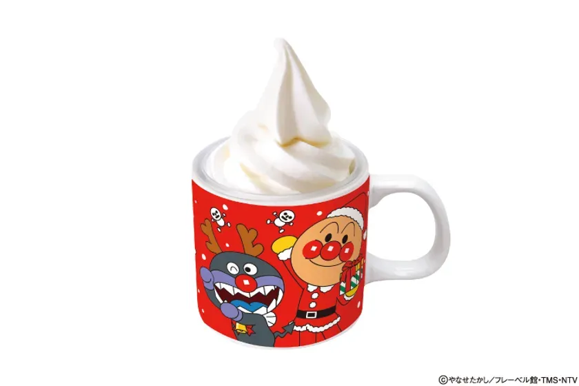 アンパンマンのキャラクターが描かれたマグカップに入ったソフトクリームの写真。クリスマス仕様で、カップにはサンタクロース姿のアンパンマンとバイキンマンが描かれています。