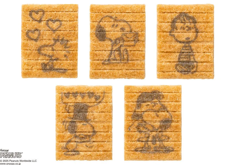 スヌーピーのキャラクターが描かれた、ビスケットのような焼き菓子が写った写真。それぞれ異なるデザインで、様々なポーズのスヌーピーやチャーリー・ブラウンなどが描かれている。一部のビスケットには「LOVE」の文字とハートマークも。