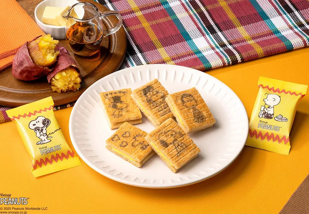 スヌーピーのキャラクターが描かれたクッキー、焼き芋、バター、シロップなどがテーブルに並べられた写真です。