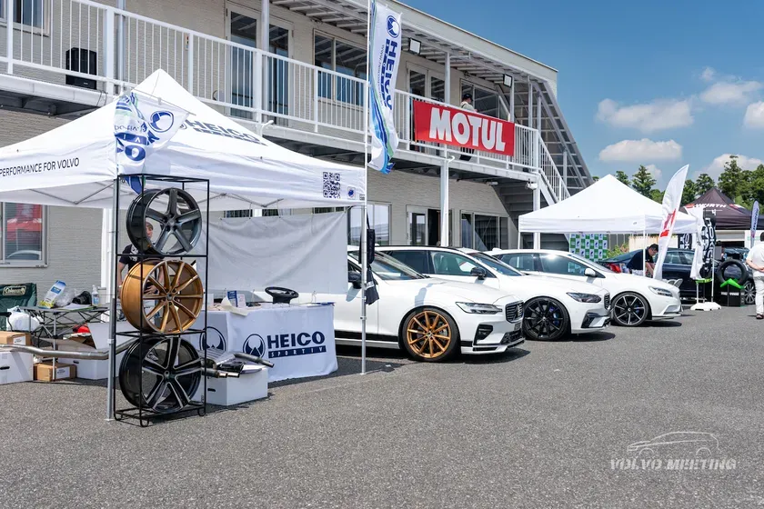 白のボルボ車が並び、HEICO SPORTIVのブースが出展しているイベントの様子。