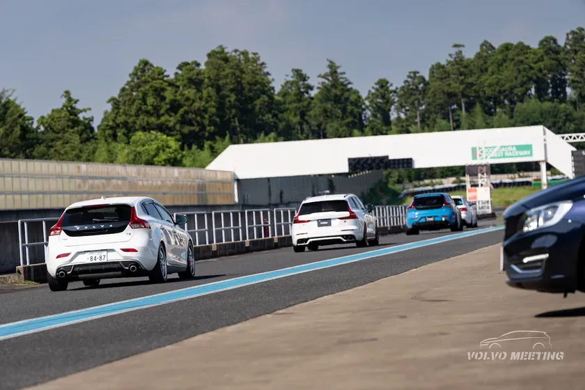 サーキットを走行するボルボの車の写真です。白い車が先頭を走り、青い車が続きます。