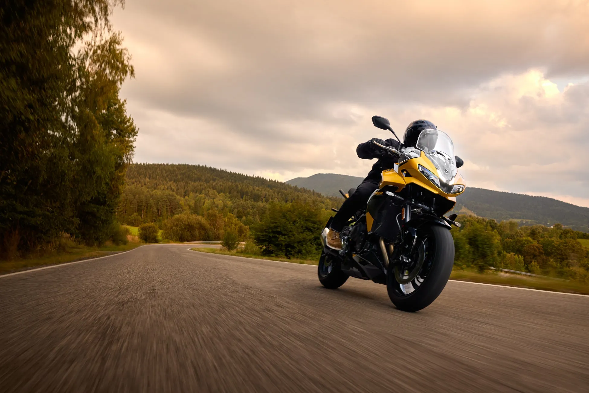 黄色いバイクが曲がりくねった道を走行している様子。