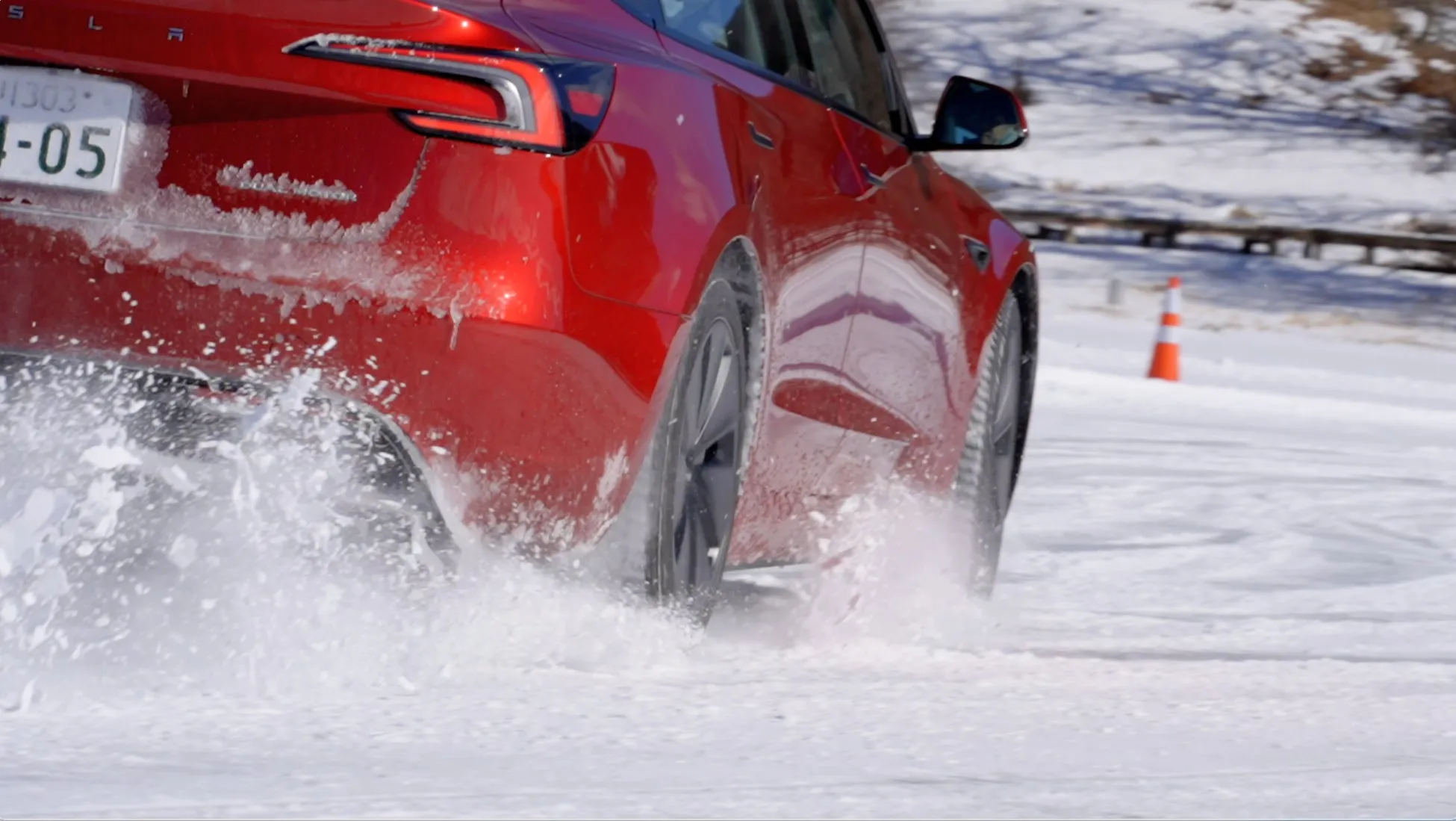 雪道を走行する赤いテスラ車