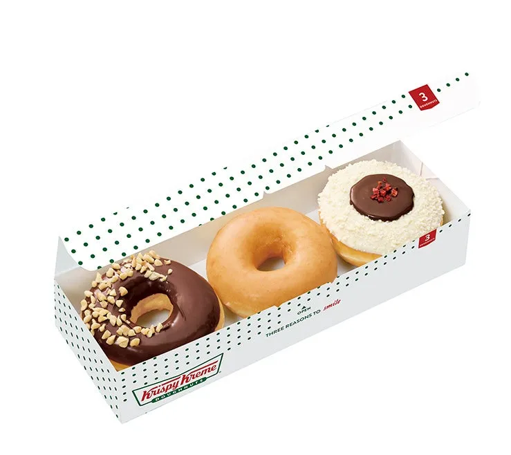 クリスピークリームドーナツの3個入りの箱。チョコレート、プレーン、トッピング付きのドーナツが入っている。