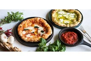 2種類のピザと、トマトソース、バジル、ニンニクなどの食材がテーブルに並べられた写真です。
