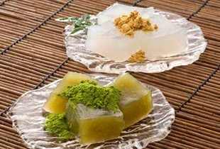 透明な器に盛り付けられた、きな粉と抹茶がトッピングされた2種類のゼリーのクローズアップ写真。