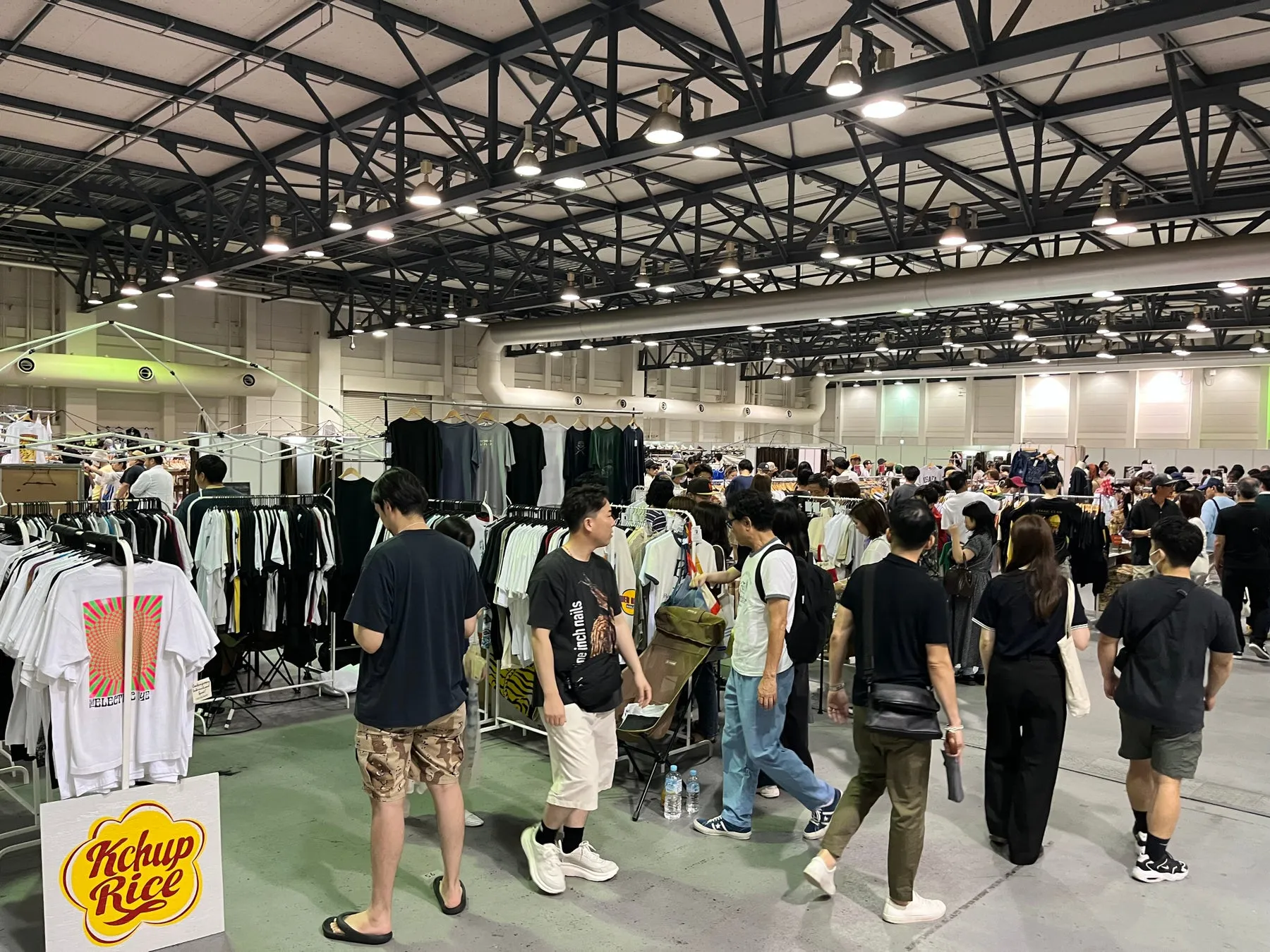 屋内イベントの様子。多くの人が集まり、衣類や雑貨などの商品が販売されている。