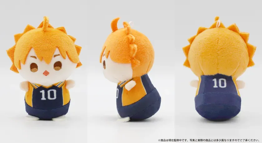 オレンジ色の髪とユニフォームを着たキャラクターのぬいぐるみ。前面、側面、背面から見た様子が写っている。