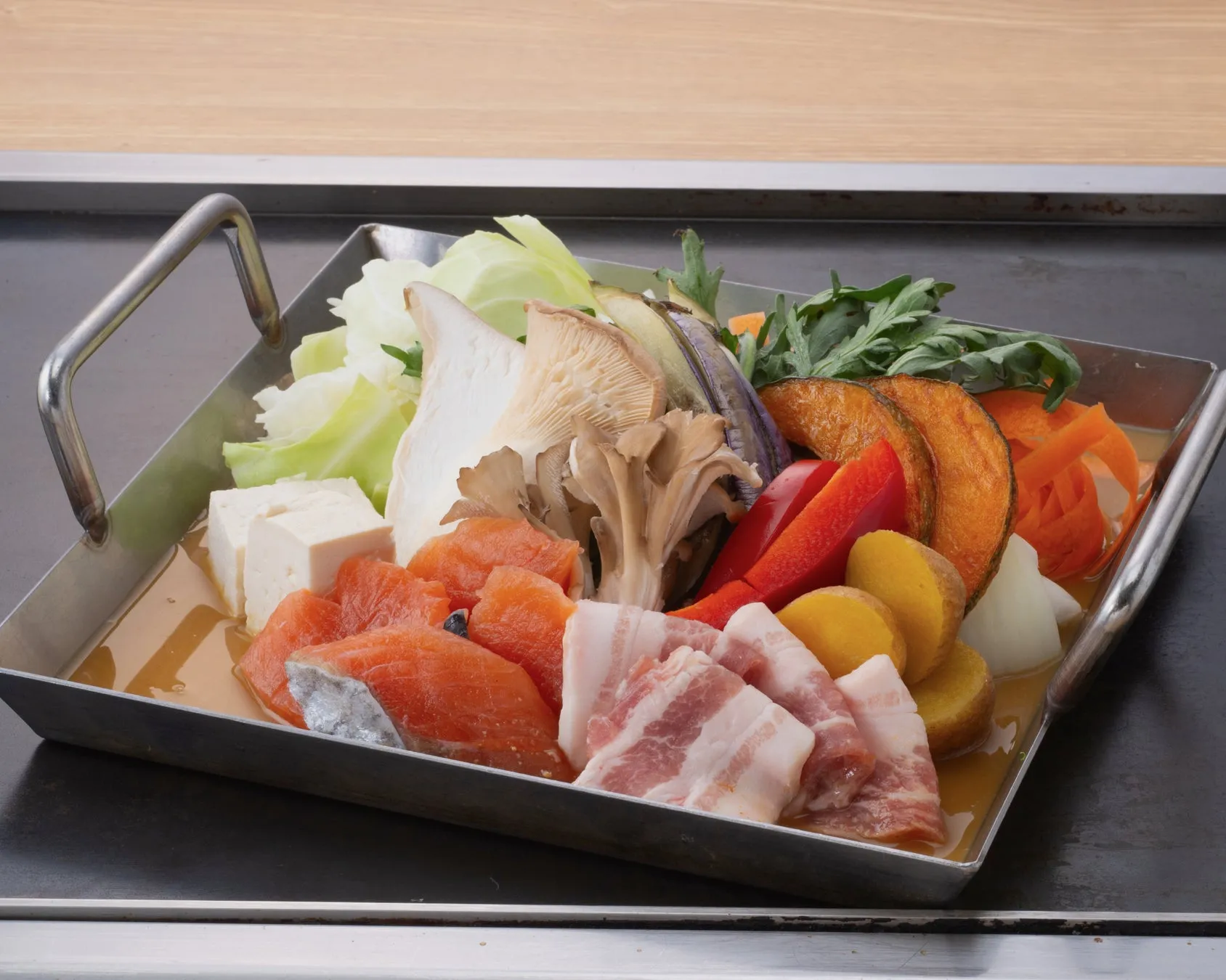 鮭、豚バラ肉、豆腐、野菜(カボチャ、ナス、パプリカ、キャベツ、きのこ、人参など)が確認できます。