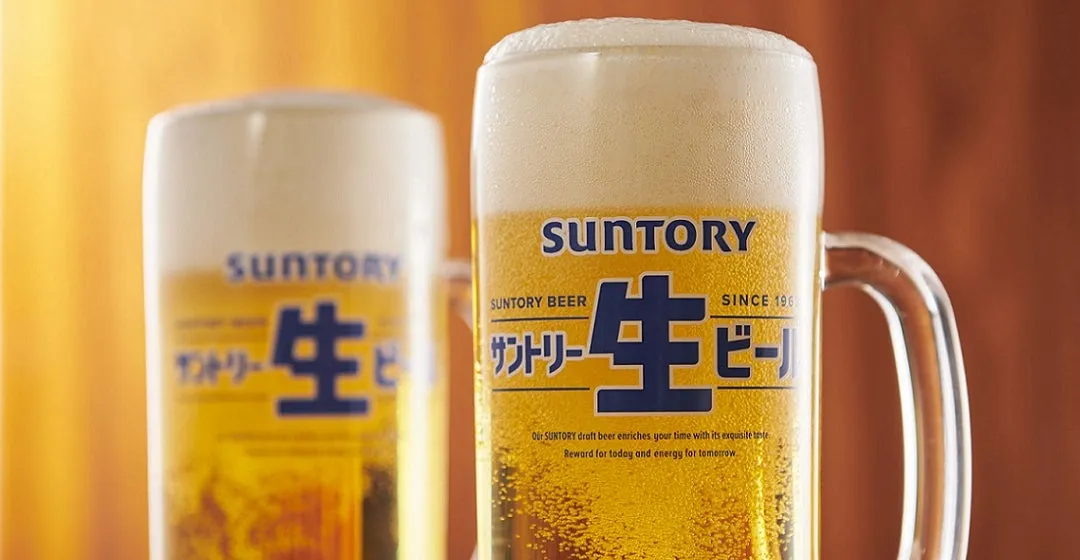 2つのビールグラスが写った写真。グラスには「SUNTORY」のロゴと「生ビール」の文字が書かれており、泡がたっぷり入っている。