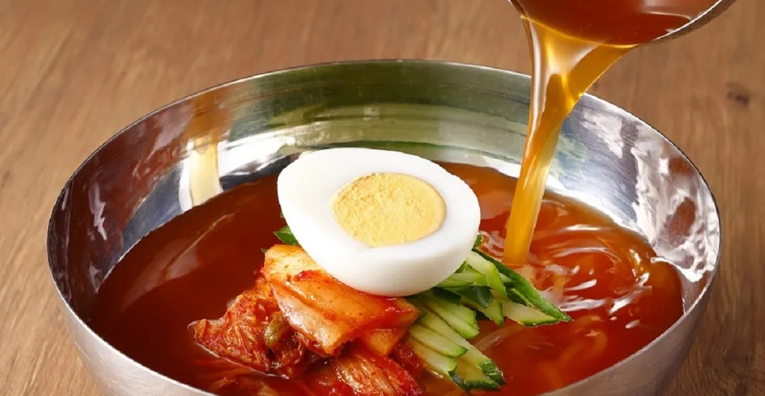 冷麺にスープを注いでいる様子