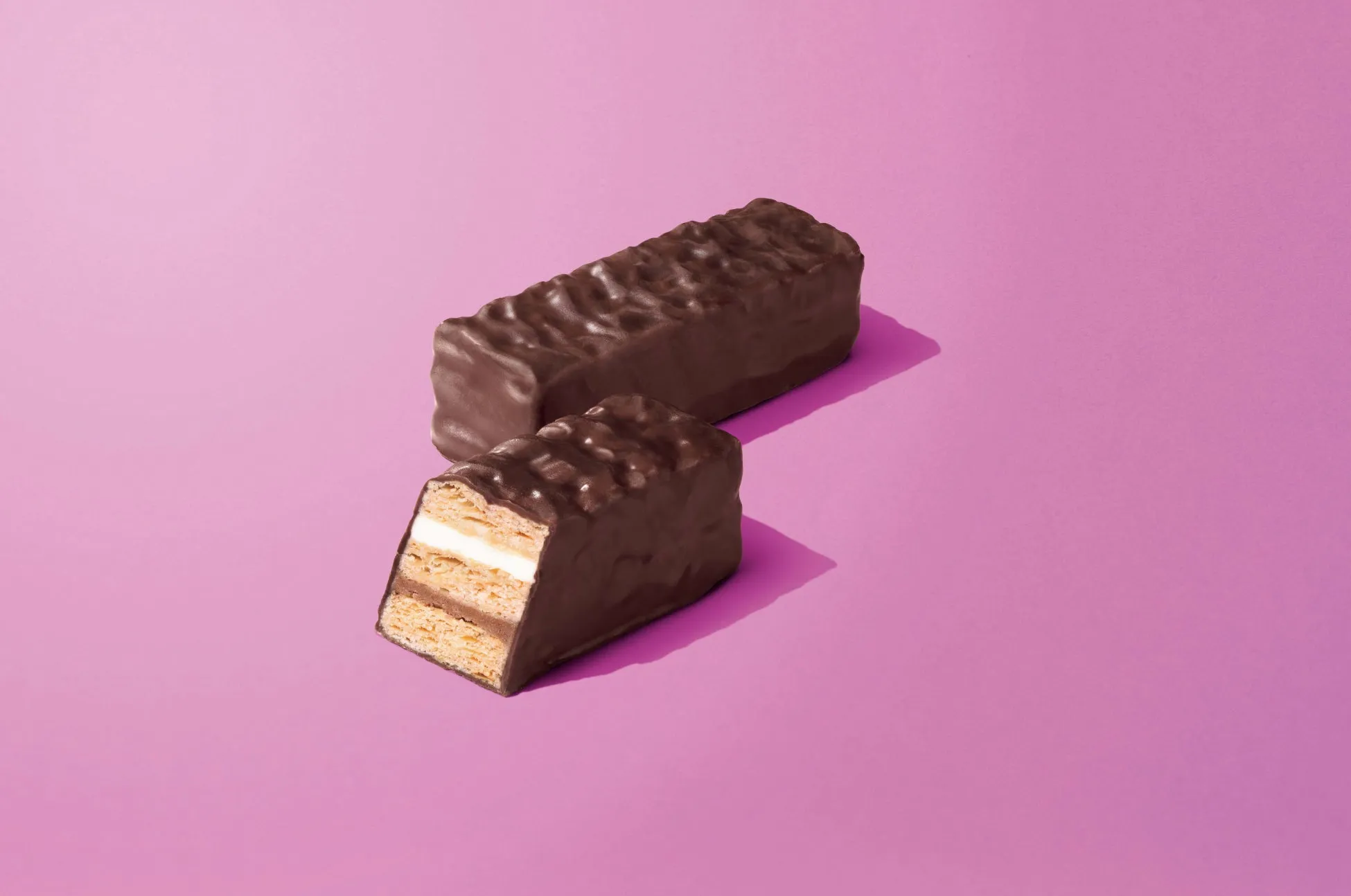 チョコレートでコーティングされたお菓子が2つ並んだ写真。一つは半分にカットされており、中身が見える。