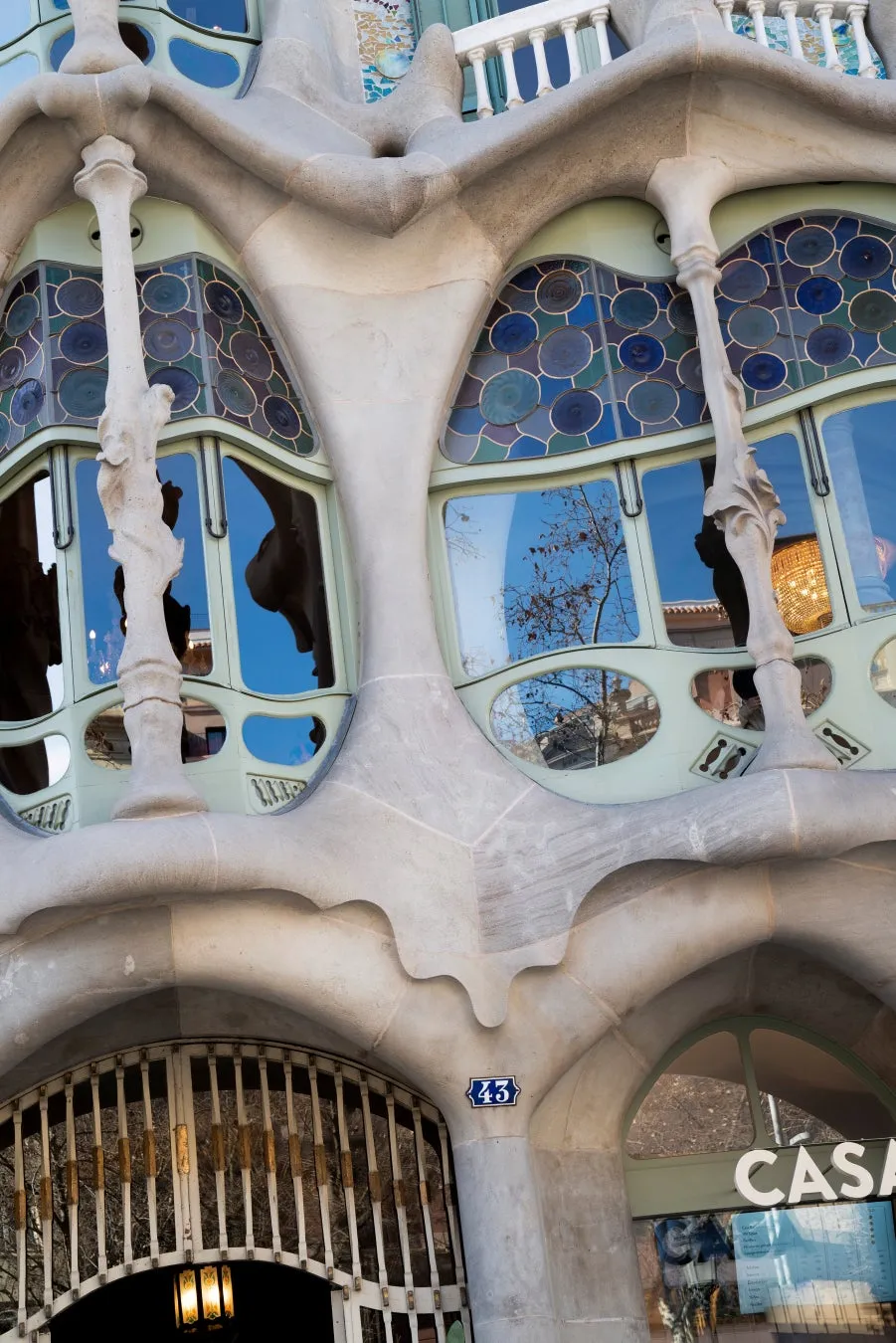 ガウディ建築の建物の正面玄関と窓のクローズアップ写真。